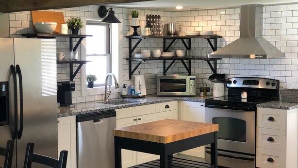 A modern kitchen with white cabinetry, a black countertop, and stainless steel appliances. - Das Gästehaus • 50 Min to KC Stadium • World Cup 2026 (Concordia)