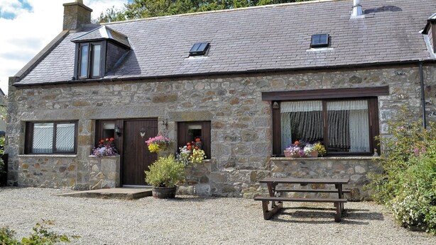 A stone cottage with a sloped roof, a chimney, and a gravel driveway. - Cosy Cottage with Log burner very tranquil in gorgeous rural setting (Huntly)