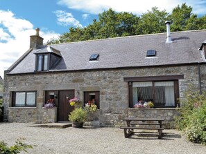 A stone cottage with a sloped roof, a chimney, and a gravel driveway. - Cosy Cottage with Log burner very tranquil in gorgeous rural setting (Huntly)
