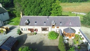 A stone farmhouse with a large barn, surrounded by greenery and a gravel driveway. - Cosy Cottage with Log burner very tranquil in gorgeous rural setting (Huntly)