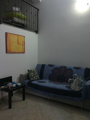 Relax in this stylish living room with a sofa, coffee table, and artwork on the wall.