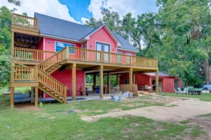 A two-story house with a wooden deck and a covered porch.