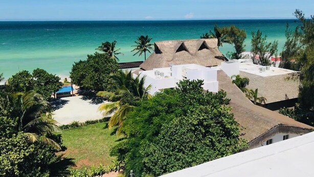 A beachfront property with thatched-roof buildings, a pool, and lush greenery. - Artistic Mayan Accommodations - AMA 2C (Boulevard Turístico Bording)