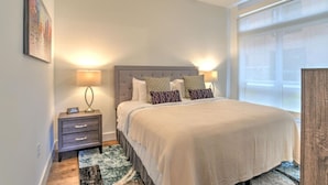 Une chambre à coucher avec un lit, des lampes de chevet, une table de chevet, un tapis et une fenêtre.