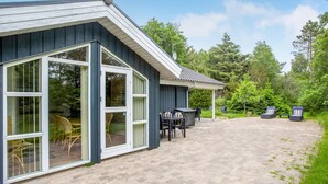 A building with large windows and a patio area with outdoor furniture. - Pet friendly home in ålbæk with sauna (Ålbæk)