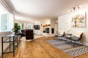 A living room with a fireplace, a sofa, a coffee table, and a TV.