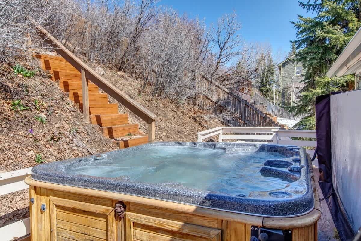 Ein Whirlpool in einem Garten mit einer Holztreppe und einer Holzterrasse.