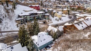 A residential area with modern houses, a ski slope, and a road.