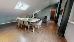 Un moderno loft con zona pranzo, pavimento in legno e lucernari.