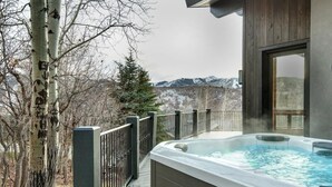 A hot tub on a wooden deck with a view of mountains. - Abode at Bluebird, private hot tub, steps to Main Street & trails (Park City)