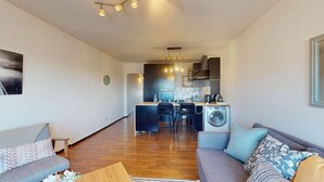 Un apartamento moderno con sala de estar, cocina y lavandería.
