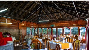 A restaurant with wooden interiors, multiple tables, and chairs. - Thomson Falls Lodge (Nyahururu)