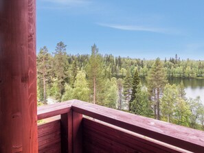 A wooden deck overlooking a forested lake. - Länsirinne d 16 by Interhome (Kuusamo)