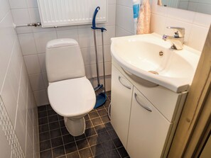 A bathroom with a toilet, a sink, and a mop. - Länsirinne d 16 by Interhome (Kuusamo)