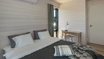 Een slaapkamer met een bed, een bureau en een stoel.