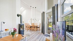 Eine moderne Küche mit Holztisch, Einbauherd und großem Fenster.