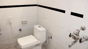 Ein kleines Badezimmer in Weiß mit Toilette, Bidet und Dusche.