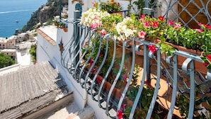 A white building with a balcony overlooking a coastal view. - CASA PERLA - Positano AMALFI COAST (Positano)
