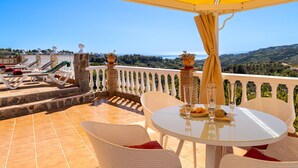 Una terraza con mesa lista para comer, con vistas a un paisaje pintoresco.