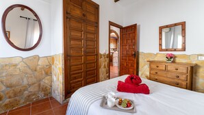 Un dormitorio con pared de piedra, armario de madera y cama con una bandeja de desayuno.