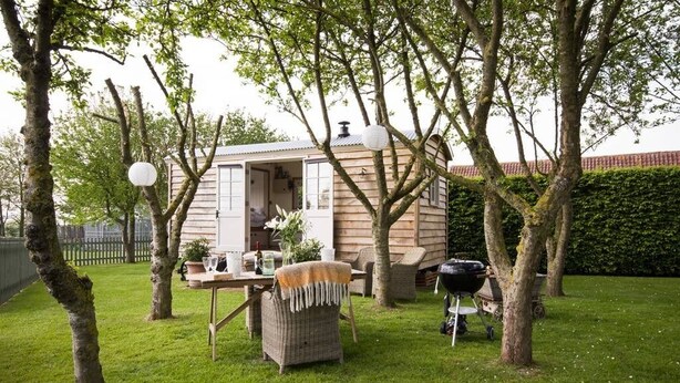 A cozy outdoor seating area with a table, chairs, and a barbecue grill. - Secluded and Luxurious Shepherd's Hut (Melksham)