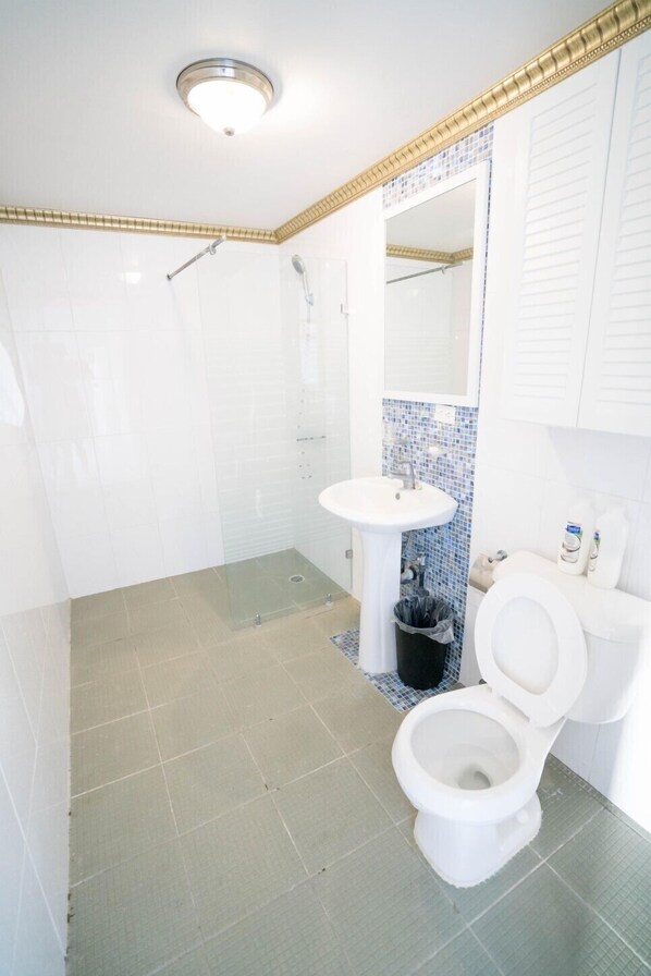 A bathroom with a shower, toilet, and sink.