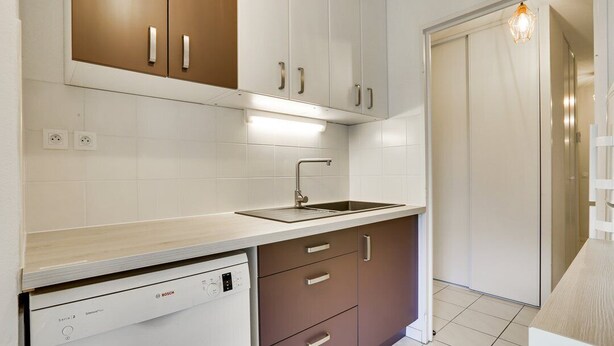 Een moderne keuken met witte kasten, een Bosch vaatwasser en een spoelbak.