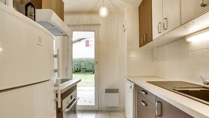Een moderne keuken met witte kasten, een inbouwoven en een gootsteen.