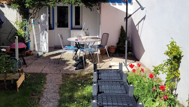 A patio with a table and chairs, a small garden, and a white wall. - Au Vieil, Small fisherman's house (Noirmoutier-en-l'Île)