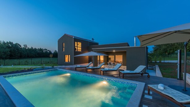 A modern house with a swimming pool, outdoor seating, and a covered patio area. - Luxury villa Sorella in Istria, private pool (Barban)