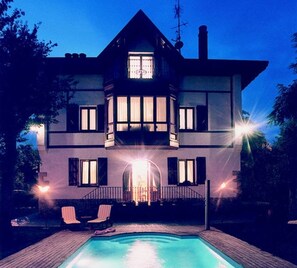 Una casa de dos pisos amb una piscina al davant.