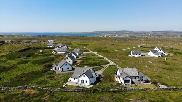En kystlandsby med hvide huse, klar himmel og udsigt til havet.