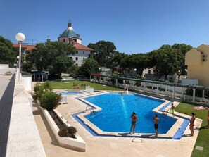 Relax by the resort's central pool surrounded by lounge chairs and a covered seating area.