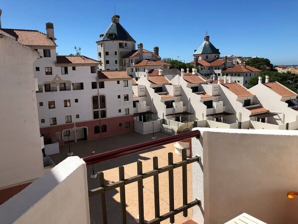 Residential buildings with red-tiled roofs and balconies line the streets.