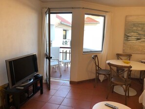 Relax in this cozy space with a TV for entertainment, a dining area for meals, and large windows offering views of the surrounding area.