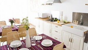 Una cocina moderna con armarios blancos, encimera de madera y estufa empotrada.