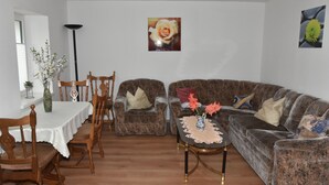A living room with a dining table, two sofas, and a coffee table. - King cottage in the center (Königsbrück)