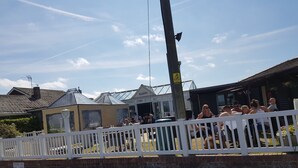 Un espace extérieur clos, délimité par un mur de briques et agrémenté d’un panneau indiquant que les visiteurs doivent payer des frais de 75 £ pour pouvoir quitter les lieux.