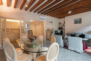 A modern living space with a dining area, kitchen, and seating area.