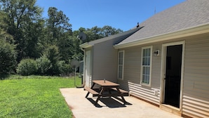 A house with a patio, a satellite dish, and a door leading to a garage.