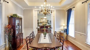 A dining room with a wooden table, chairs, a chandelier, and a cabinet with a mirror. - Historic Silverton Home 5 BR, 6 Bath.  Ask about 6th & 7th bedroom add-ons. (Silverton)