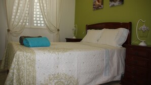 A neatly made bed with a blue towel, a wooden headboard, and a nightstand with a lamp.