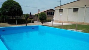 Ein rechteckiger Swimmingpool mit glasklarer blauer Wasseroberfläche, umgeben von einem Zaun.
