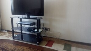 A television on a stand with a shelf below it. - Квартира центр города (Baku)