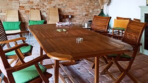 A rustic dining area with a wooden table and chairs, a brick wall, and a decorative wooden shelf with hanging lights. - Independent flat 2 pax downstairs, in Villa, Siena View, Pool A/C, organic Farm (Siena)
