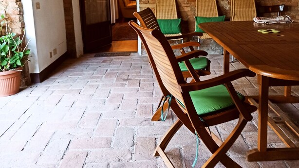 A rustic dining area with a brick floor, wooden furniture, and a brick wall. - Independent flat 2 pax downstairs, in Villa, Siena View, Pool A/C, organic Farm (Siena)