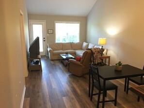 Cozy living space with a sofa set, dining table, and television.