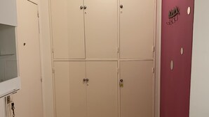 Una habitación con un armario grande, un espejo y un suelo de madera con estampado de espiga.