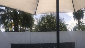 A swimming pool with a hot tub, a waterfall feature, and a white brick wall in the background. - Entire Single Family Home with Pool.  Old Town Scottsdale! License #2037712 (Scottsdale)