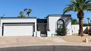 A two-story house with a garage, a small front porch, and a palm tree. - Entire Single Family Home with Pool.  Old Town Scottsdale! License #2037712 (Scottsdale)